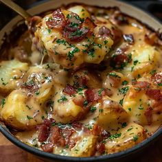 a skillet filled with potatoes covered in cheese and bacon, topped with parsley