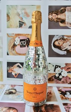 a bottle of champagne sitting on top of a table next to pictures and other items