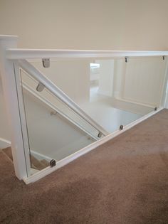 an empty room with carpeted flooring and white railings on the bottom level