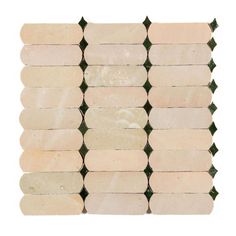 the back side of a white and green mosaic tile wall with several different sized tiles on it