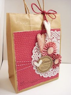 a brown paper bag with red and white doily on the front, tag attached to it