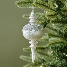 a white ornament hanging from a christmas tree