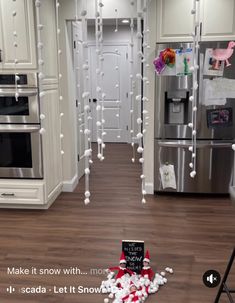 a kitchen decorated for christmas with candy canes on the floor and decorations hanging from the ceiling