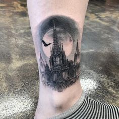 a black and white photo of a castle on the leg with a bird flying over it