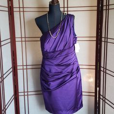 a purple dress is on display in front of a mannequin