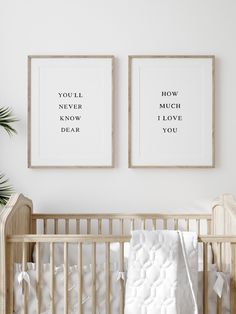 two framed posters above a crib in a white room