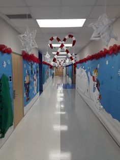 an empty hallway decorated with christmas decorations and paper snowflakes on the ceiling,