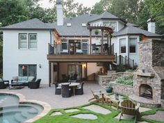 a house with a hot tub in front of it next to a patio and fire pit