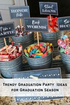 some buckets filled with candy sitting on top of a counter next to chalkboard signs