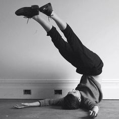 a man doing a handstand on the floor with his feet in the air