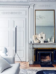 a living room filled with furniture and a fire place in front of a painting on the wall