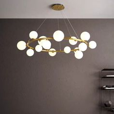 a modern chandelier hanging from the ceiling in a room with grey walls and flooring