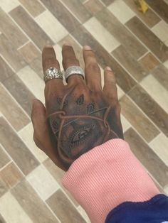 a person with tattoos on their hand holding something