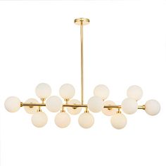 a chandelier with white glass balls hanging from it's brass finish frame