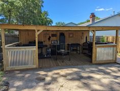 a backyard shed with an outside kitchen and grilling area in the middle of it