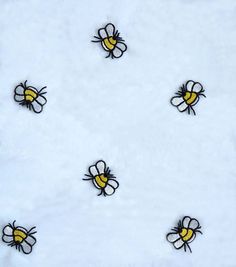 the bees are flying around on the white snow covered ground with black and yellow patches