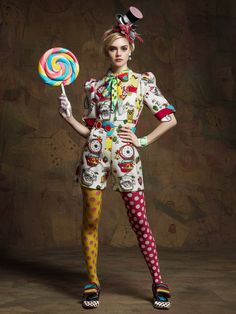 a woman in clown costumes holding a lollipop