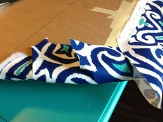 a blue and white cloth sitting on top of a table next to a cardboard box