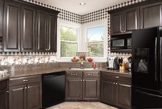 a kitchen with dark brown cabinets and black appliances in the corner, along with checkered wallpaper