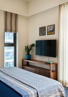 a bedroom with a large flat screen tv mounted on the wall