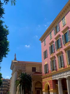 an old building with columns in front of it and palm trees on the other side