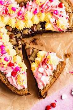 a heart shaped cake with pink and yellow frosting on it's crusts