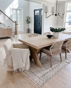 a dining room table with chairs and a potted plant on top of the table