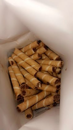 a pile of rolled up food sitting inside of a white container