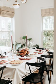 a dining room table set with food and candles