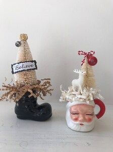 two ceramic figurines sitting next to each other on top of a white table