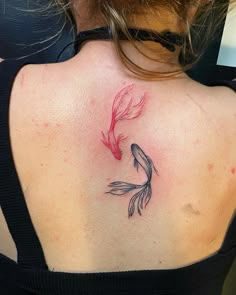 a woman with a tattoo on her back that has a goldfish in the water