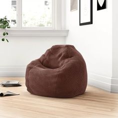 a bean bag chair sitting on top of a hard wood floor next to a window