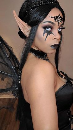 a woman with black makeup is dressed as a fairy