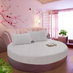 a large round bed in a room with pink walls