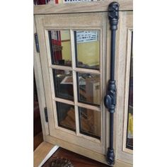 a wooden cabinet with glass doors on the front and side, next to a pine cone