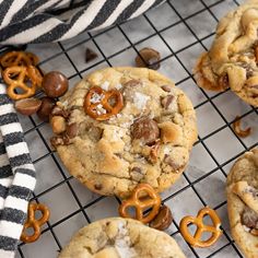 chocolate chip cookies with pretzels and salt on a cooling rack next to a striped towel