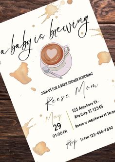 a baby is brewing party card with a cup of coffee on it and watercolor stains