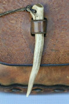 a brown leather purse with a long horn handle