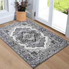 a large rug on the floor in front of an open door with a basket full of flowers