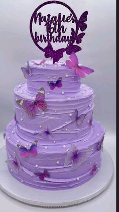 a purple birthday cake with butterflies on it