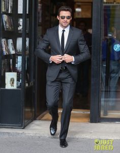 a man in a suit and tie is walking down the street