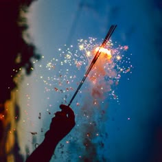 a person holding an umbrella with fireworks in the background