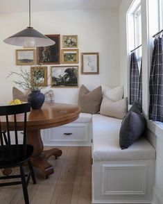 a room with a table, bench and pictures on the wall above it is shown