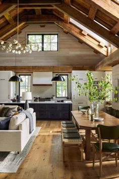 a living room filled with furniture next to a kitchen and dining room table on top of a hard wood floor