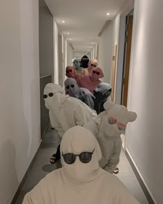 a group of people in costumes walking down a hallway