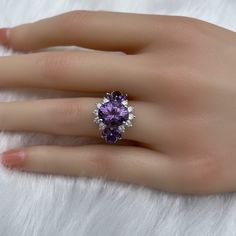 The key stone of this ring is a 11x9mm natural amethysts, and the main material of this ring is sterling silver plated with 18k white gold. On each side of the main stone are one 5x3mm and two 5x2.5mm amethysts. The small accent stones and zircon emphasize the big size of the key stone. Amethyst is a birthstone for February, and the color purple is meant to bring wealth and royalty. Also, many people believe amethyst has the power to relieve stress and purify the mind. Size: Adjustable and fitab Cluster Diamond Gemstones For Wedding, Luxury Amethyst Ring With Halo Setting For Promise, Luxury Amethyst Promise Ring With Halo Setting, Luxury Amethyst Halo Setting Promise Ring, Exquisite Cubic Zirconia Gemstones For Anniversary, Formal Cubic Zirconia Gemstones, Elegant Gemstones With Prong Setting For Promise Ring, Diamond White Multi-stone Fine Jewelry Ring, Cubic Zirconia Anniversary Gemstone Round Cut