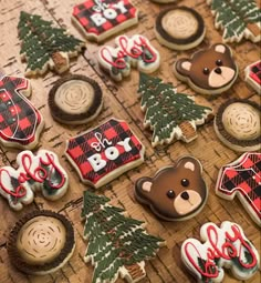 decorated cookies are arranged on a table with christmas trees and bear decorations in the background