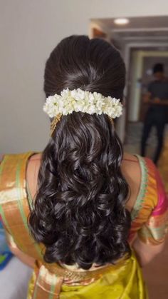 the back of a woman's head with flowers in her hair