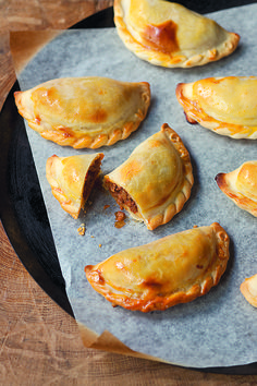 several pastries sitting on top of a pan covered in wax paper