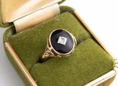 Beautiful and classic black onyx ring.  This vintage, feminine style ring has an oval black onyx with one diamond set in the center.  The shank is accented by a pierced and sculpted floral motif.  The setting is low to the finger and would be comfortable for daily wear.   Top of ring: 13.00 x 10.50mm  Bottom of ring: 1.75mm Diamond: Single Cut  Approximately .005ct Finger Size: 5  Material: 10 Karat Yellow Gold Black Oval Engraved Hallmarked Ring, Elegant Oval Onyx Signet Ring, Formal Oval Black Enamel Signet Ring, Vintage Black Oval Engraved Ring, Elegant Black Enamel Engraved Ring For Formal Occasions, Elegant Formal Engraved Ring With Black Enamel, Vintage Feminine Style, Vintage Feminine, Black Onyx Ring